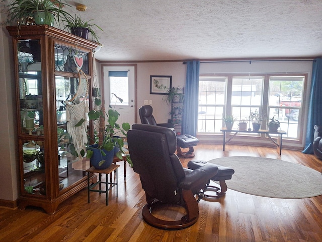 living room featuring hardwood / wood-style flooring, crown molding, and a textured ceiling