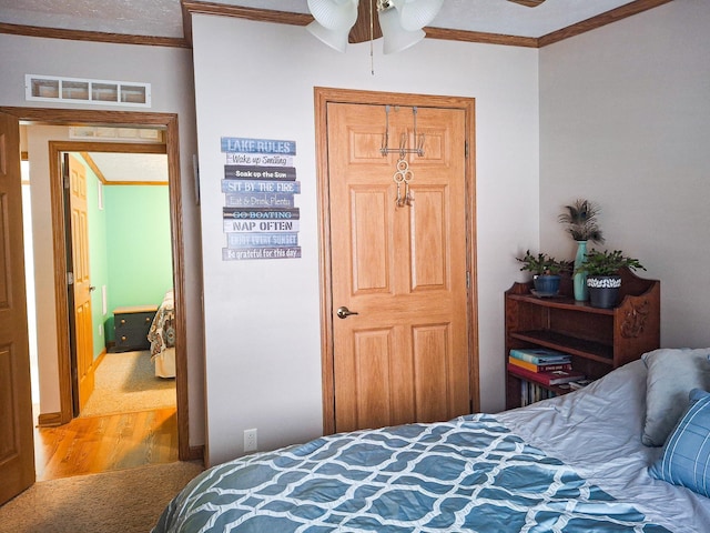 bedroom featuring crown molding and wood-type flooring