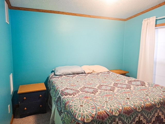 bedroom with ornamental molding, carpet floors, and a textured ceiling