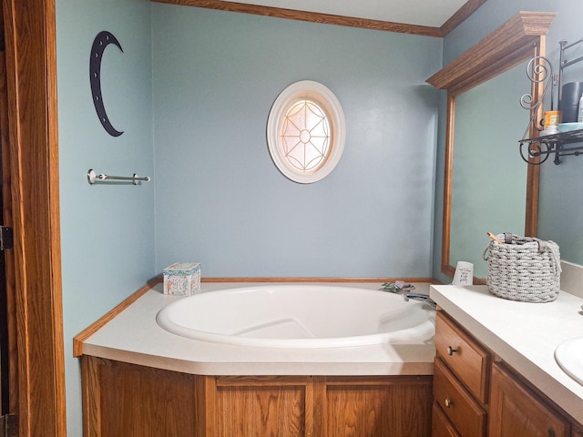 bathroom with vanity, crown molding, and a bathtub