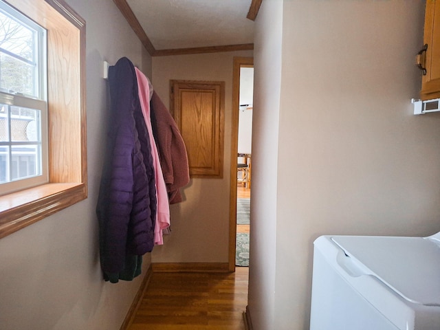 washroom featuring hardwood / wood-style flooring, crown molding, separate washer and dryer, and cabinets