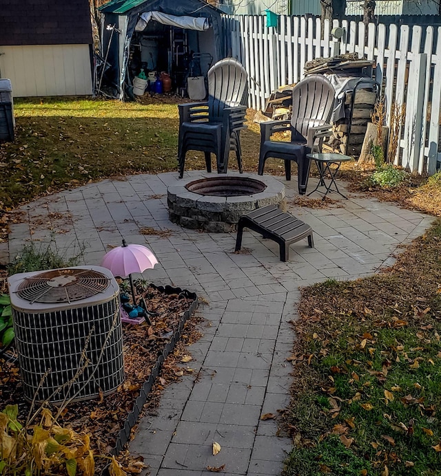 view of patio / terrace featuring a storage shed, an outdoor fire pit, and central air condition unit