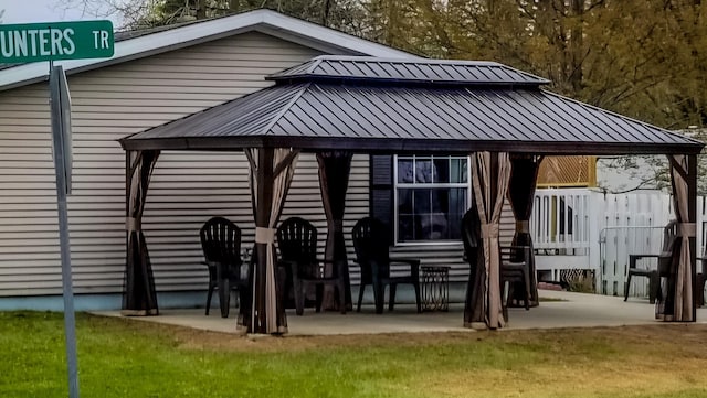 back of property with a yard, a patio area, and a gazebo