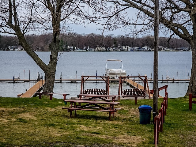 view of dock featuring a water view and a lawn