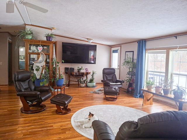 living room featuring vaulted ceiling, crown molding, hardwood / wood-style floors, and a textured ceiling