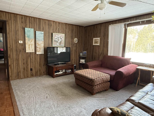 living room featuring ceiling fan and wooden walls