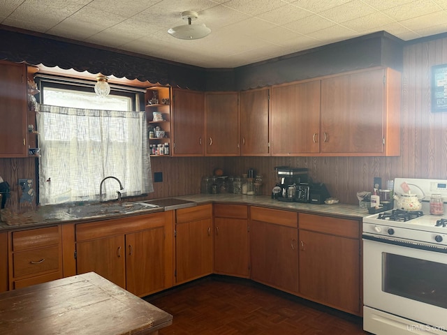 kitchen featuring dark parquet floors, sink, and gas range gas stove