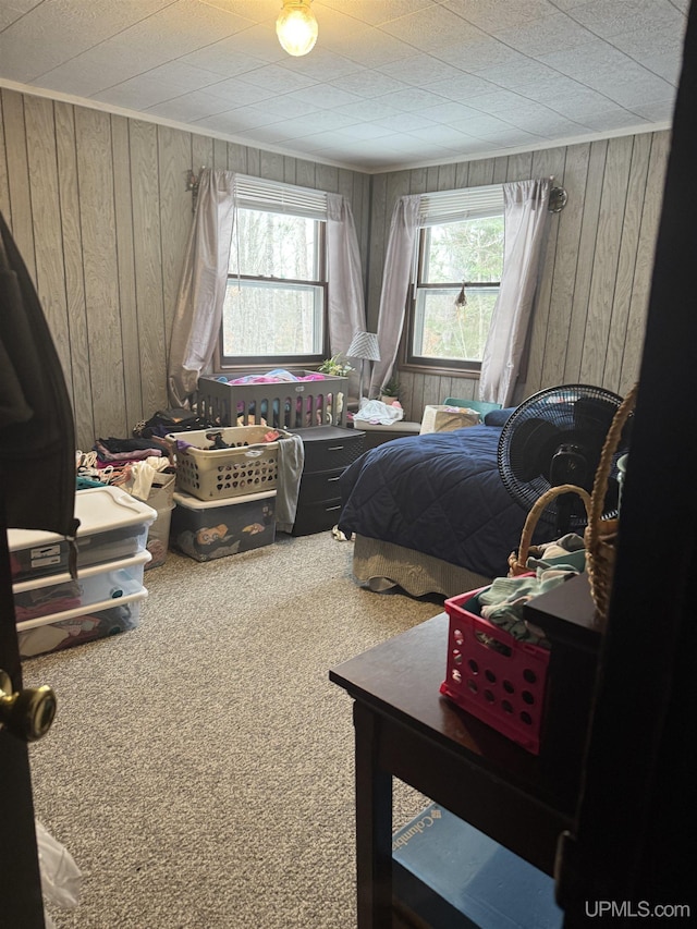 bedroom featuring wood walls and carpet