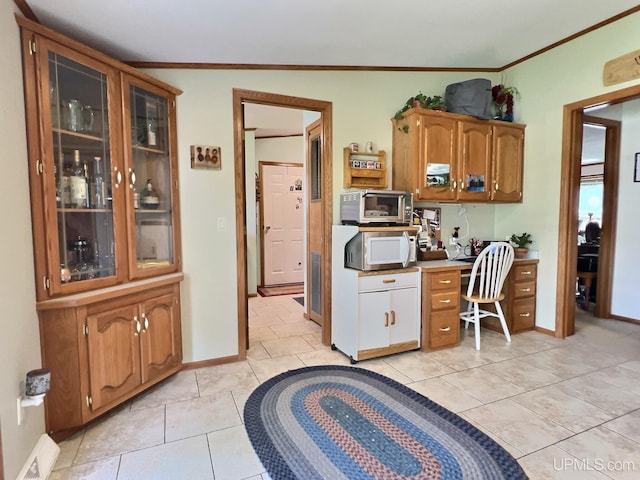 kitchen with light tile patterned floors and crown molding