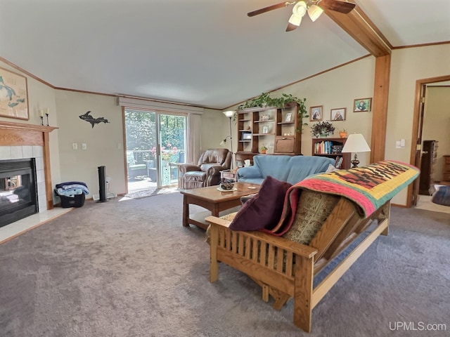 carpeted living room with a tiled fireplace, vaulted ceiling, ornamental molding, and ceiling fan