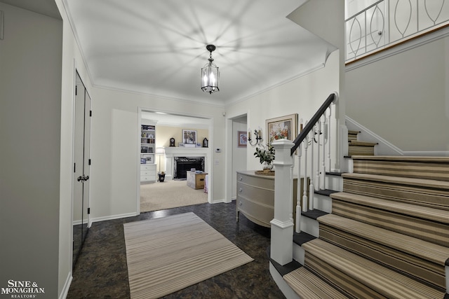 foyer with ornamental molding and a high end fireplace