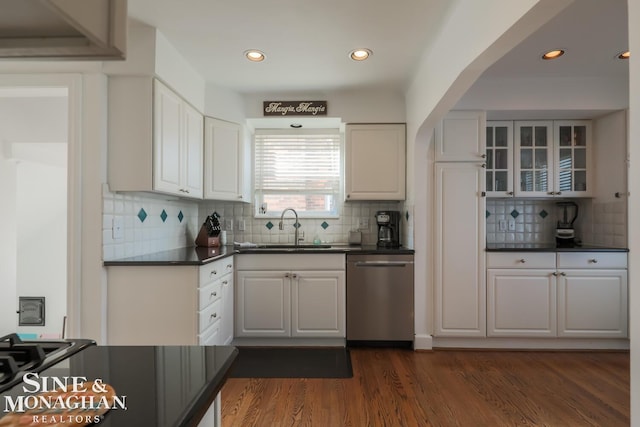 kitchen with dark hardwood / wood-style floors, white cabinetry, dishwasher, sink, and decorative backsplash