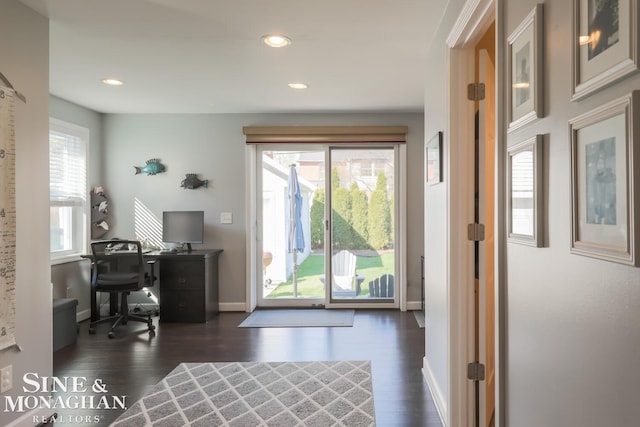 home office with dark wood-type flooring and plenty of natural light