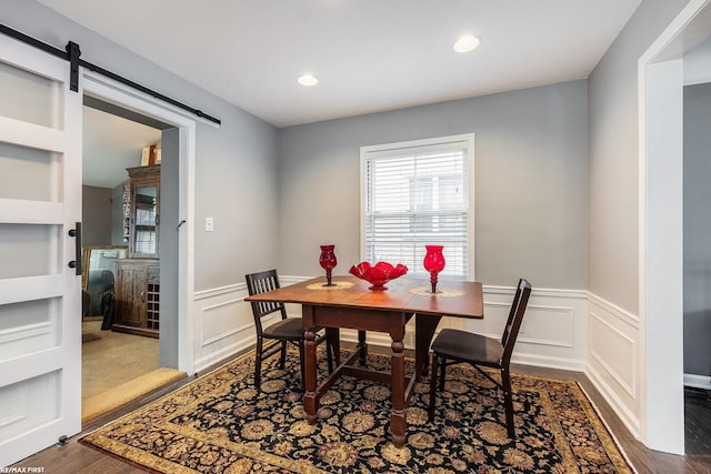 dining room featuring a barn door and dark hardwood / wood-style flooring