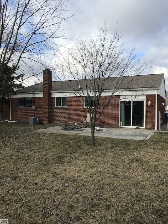 rear view of property with a yard, central AC unit, and a patio area