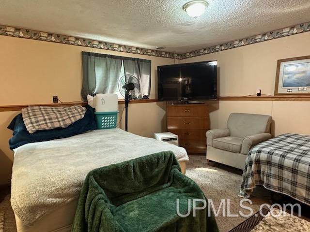 carpeted bedroom featuring a textured ceiling