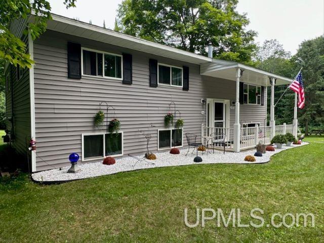 rear view of property featuring a lawn