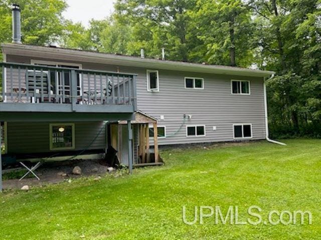 rear view of house featuring a yard and a deck