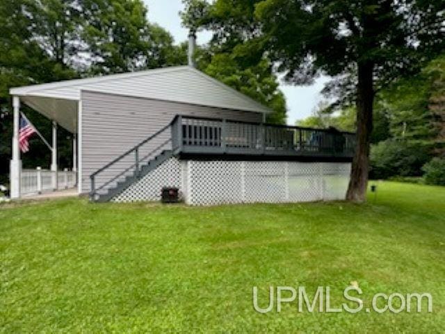 back of property with a wooden deck and a lawn