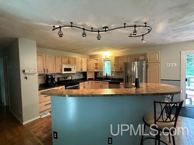 kitchen featuring backsplash, dark wood-type flooring, and appliances with stainless steel finishes