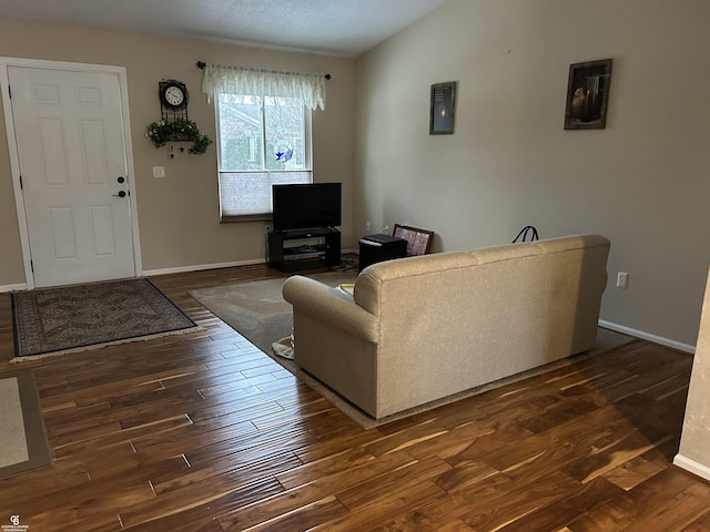 living area with dark wood-style floors, lofted ceiling, and baseboards