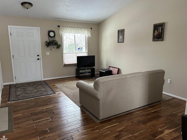 living area with vaulted ceiling, dark wood finished floors, a textured ceiling, and baseboards