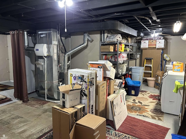 unfinished basement featuring heating unit and separate washer and dryer