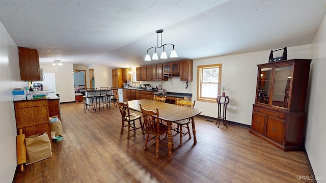 dining room featuring hardwood / wood-style flooring and vaulted ceiling