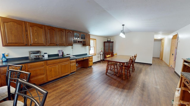 kitchen featuring hardwood / wood-style flooring, lofted ceiling, decorative light fixtures, and built in desk