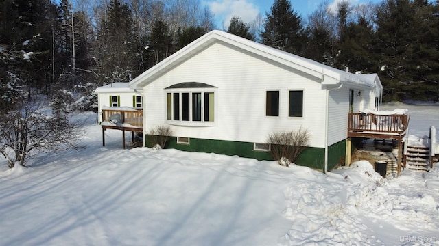 snow covered property featuring a deck