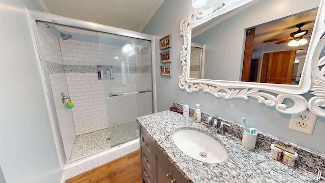 bathroom featuring vanity, ornamental molding, ceiling fan, and walk in shower