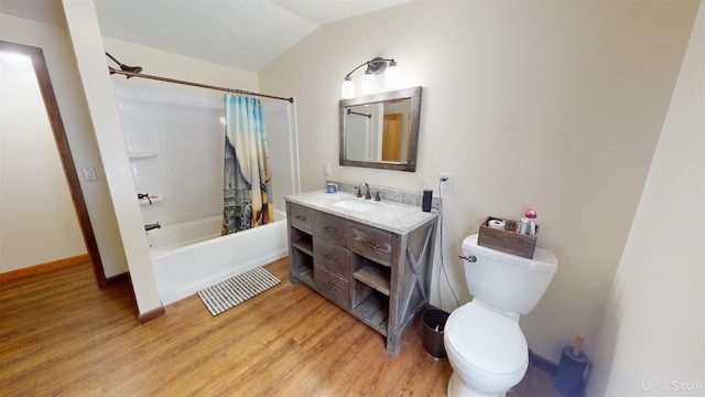 full bathroom featuring lofted ceiling, hardwood / wood-style flooring, vanity, toilet, and shower / bath combo with shower curtain