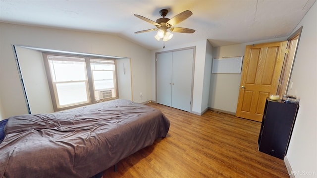 bedroom featuring lofted ceiling, light hardwood / wood-style flooring, ceiling fan, cooling unit, and a closet