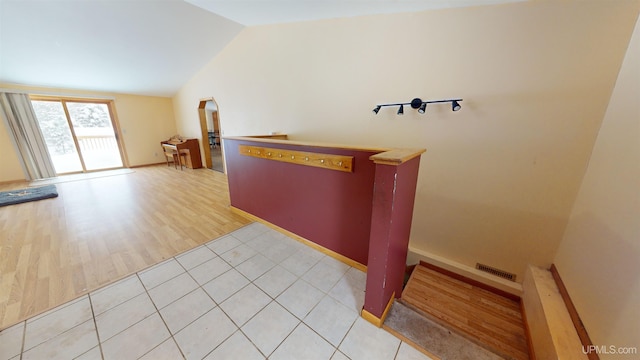 interior space with vaulted ceiling and light tile patterned floors