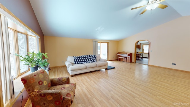 living room featuring ceiling fan, vaulted ceiling, and light wood-type flooring