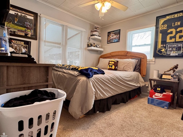 carpeted bedroom featuring crown molding and ceiling fan