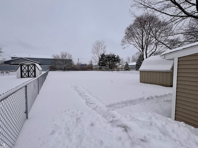 snowy yard featuring a storage unit