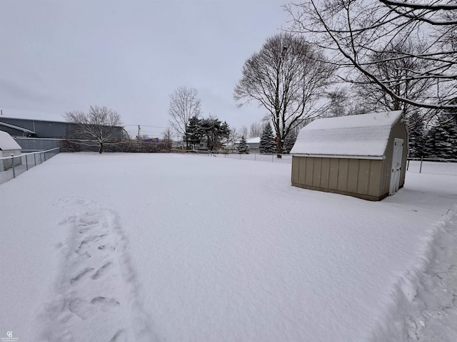 yard covered in snow with a storage shed