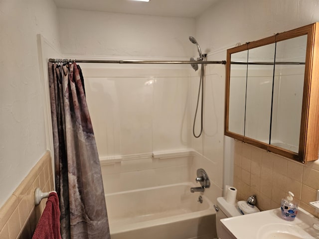 bathroom featuring shower / tub combo, toilet, and tile walls