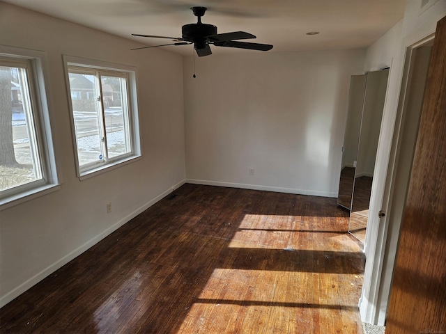 empty room with dark hardwood / wood-style floors and ceiling fan