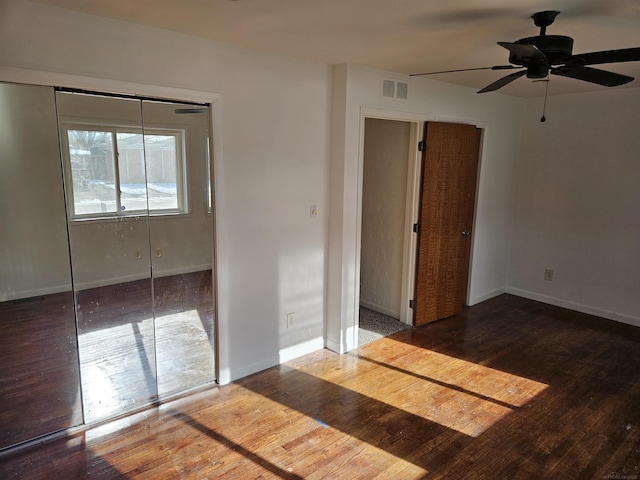 unfurnished bedroom with hardwood / wood-style flooring, a closet, and ceiling fan