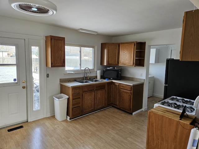 kitchen featuring sink, black appliances, and light wood-type flooring