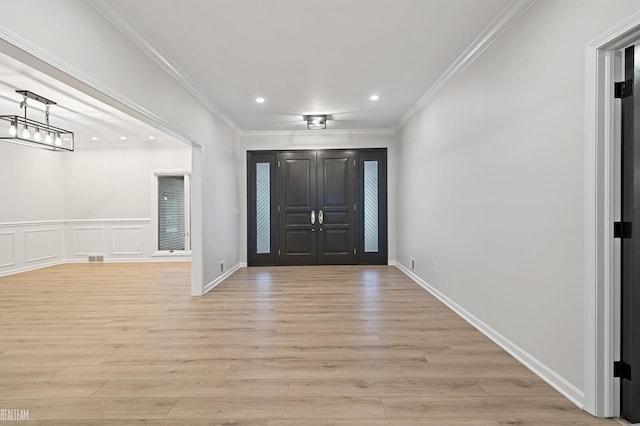 entrance foyer with crown molding, a notable chandelier, and light hardwood / wood-style floors