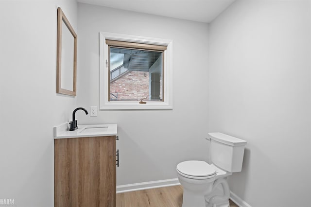 bathroom with hardwood / wood-style flooring, vanity, and toilet