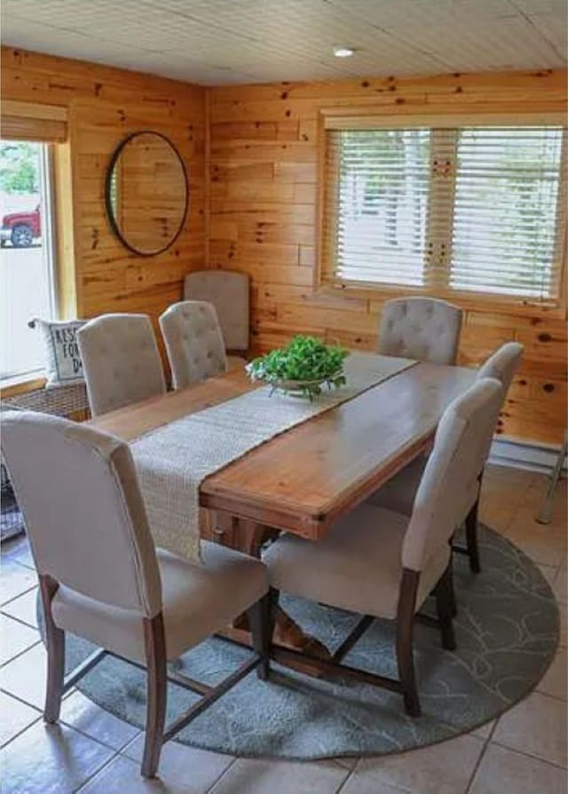 tiled dining area featuring wooden walls