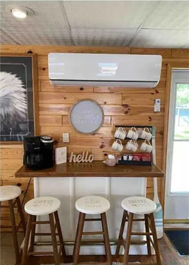 bar featuring wooden walls and a wall mounted AC