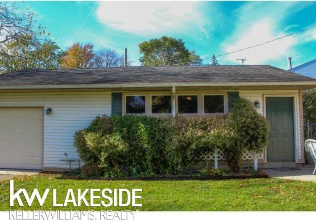 single story home featuring a garage and a front lawn