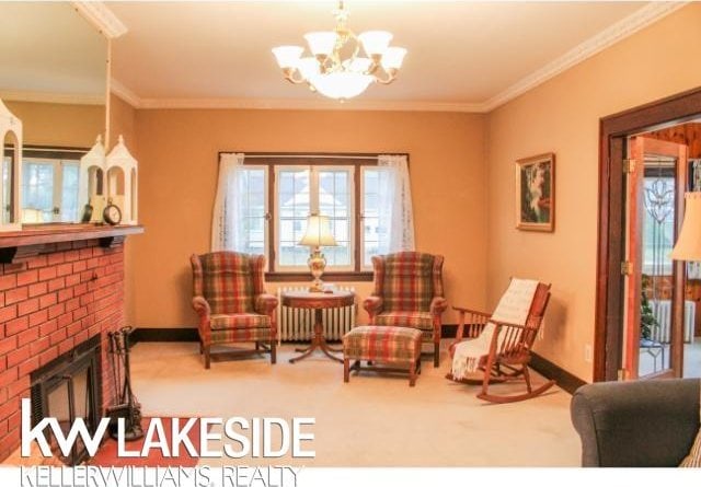 living area with ornamental molding, a fireplace, radiator, and carpet