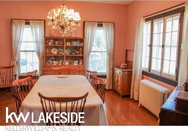 dining area with a chandelier, radiator, and light hardwood / wood-style flooring