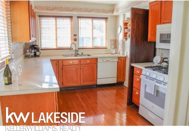 kitchen featuring tasteful backsplash, sink, white appliances, and dark wood-type flooring